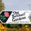 Sign reading "The Butchart Gardens" with a pink rose illustration, surrounded by flowers and greenery, under a clear sky.