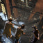 People wearing VR headsets explore a multi-level industrial space with metallic walkways and machinery.
