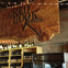 Interior of a winery with shelves of wine bottles and a wooden sign reading 'The Red Hook Winery' on a brick wall.