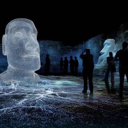 Silhouetted people observing glowing wireframe sculptures of heads in a dark, immersive digital art environment.