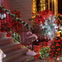 A staircase decorated with red and white Christmas lights, greenery, and holiday signs, creating a festive atmosphere.