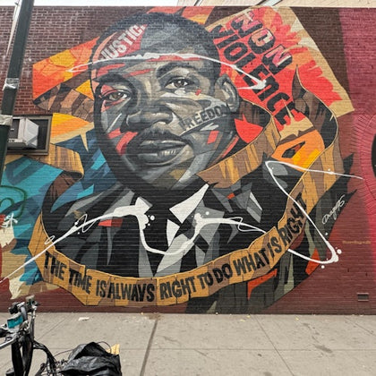 A mural on a brick wall depicting Martin Luther King Jr. with vibrant colors and phrases like "End Violence" and "The time is always right to do what's right."