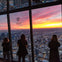 tourists gazing at chicago cityscape below at the top of 360 Chicago observatory