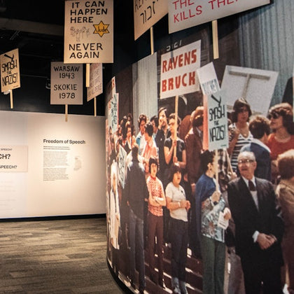 A museum exhibit displays historical protest photos and signs with messages about freedom of speech and opposition to Nazis.