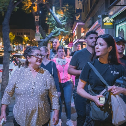 Tour guide leading her group to their next location while telling the history of the city