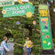 Two children happily entering a LEGO-themed 'Chill Out Zone' decorated with greenery and colorful LEGO signage.