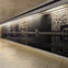 A subway corridor with a tiled floor and a wall featuring decorative panels with animal and nature motifs.
