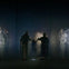 People interacting with an immersive digital art installation featuring illuminated light patterns in a dark room.