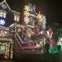 A house elaborately decorated with Christmas lights, ornaments, and figures including Santa and nutcracker soldiers at night.