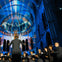 A choir performing in a cathedral with colorful light projections on the walls and ceiling.