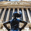 An inspiring image of the Fearless Girl Statue standing boldly before the New York Stock Exchange.