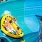 A group of people enjoying a water ride on a yellow inflatable raft within a blue water slide.