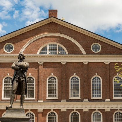 Walk in the shadow of the Samuel Adams Statue at iconic Faneuil Hall (1742)