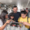A man and three children inside a submarine, interacting with equipment and controls in a confined technical space.