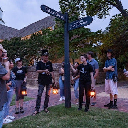 Tour guides holding a lantern having a great time with guests.