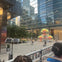 Open top double decker tour bus, passing outside art installation on Adelaide Street