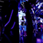 A mirrored room with purple lighting, children and adults interacting with reflective surfaces and enjoying the space.