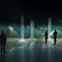 Silhouettes of people in a dark room with illuminated pillars and a projection of a jungle scene with a pyramid structure.