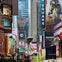 A busy urban area with numerous colorful billboards, advertisements, and traffic lights, surrounded by tall buildings.
