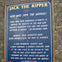A wall-mounted sign titled "Jack the Ripper" discussing historical suspects, displayed on a brick wall.