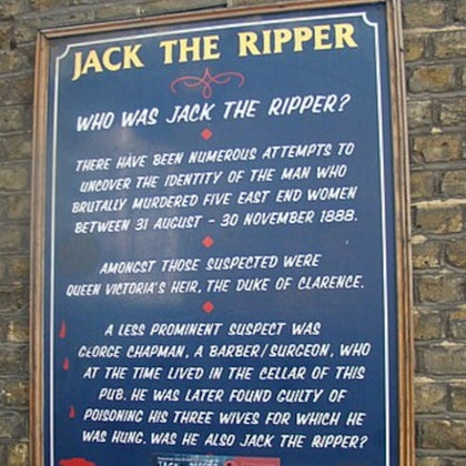 A wall-mounted sign titled "Jack the Ripper" discussing historical suspects, displayed on a brick wall.