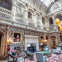 A grand, ornate room with a high ceiling, elaborate decorations, large paintings, and elegant furniture arranged around a fireplace.