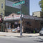 A street corner with a fish market and a person standing outside. A Metropolitan Av street sign is visible overhead.