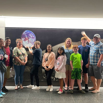 Families stop for photos in front of the "View from the Moon" during the Astroville Tunnel tour of Downtown Houston.