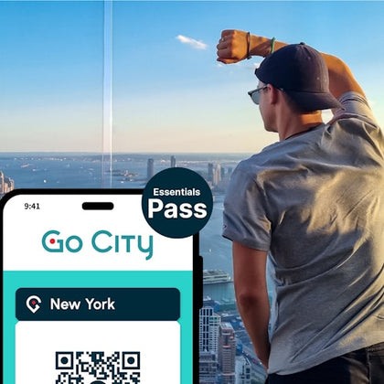 Person in a cap looking out from a tall building. Foreground shows "Go City" pass for New York on a smartphone.