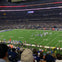 A football game in progress at a large stadium filled with spectators, with players lined up on the field's 35-yard line.