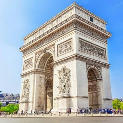 The Arc de Triomphe under a clear blue sky, with visible detailed carvings and a few people near its base.