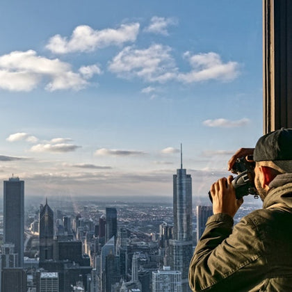 Man taking picture of view of chicago at the top of 360 Chicago observatory