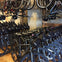 A room filled with bicycles, including rows of parked bikes and additional bikes hanging from racks above.