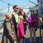 A group of people standing on a ship deck, some wearing jackets. Background includes a dome structure and other ship machinery.