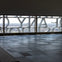 Interior view of a modern building with large windows featuring decorative text and a cityscape in the background.