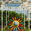 A colorful flower sculpture in a greenhouse with plants and hanging flower decorations.