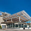 The exterior of the New England Aquarium featuring a modern glass and wood canopy under a clear blue sky.