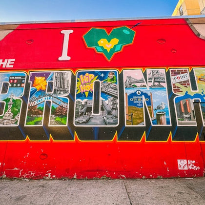 A vibrant mural with the text "I ❤️ THE BRONX" featuring various landmarks and cultural elements within each letter.