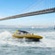A speedboat with 'RocketBoat' branding moves on water with a city skyline, including the Transamerica Pyramid, in the background.