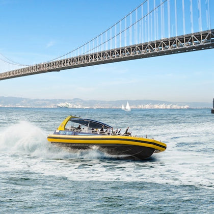 A speedboat with 'RocketBoat' branding moves on water with a city skyline, including the Transamerica Pyramid, in the background.