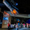 People viewing space capsules and starry exhibits in a space museum.