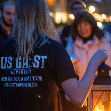 Tour guide telling ghost stories by lantern light