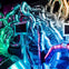 A labyrinth of shiny metallic pipes illuminated by colorful lights, with rectangular screens integrated into the structure.