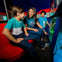 A woman and two children look at aquatic life through a glass panel inside a colorful underwater-themed exhibit.