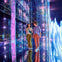 Two people walking through a colorful, mirrored hallway with vibrant lights and a futuristic ambiance.