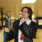 A person dressed in a costume resembling a wizard, holding a wand, standing in a subway station.