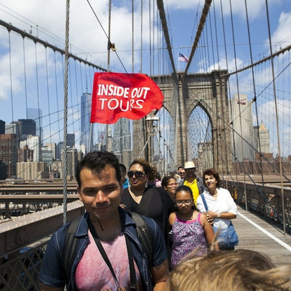Capture a stunning moment of our tour guide leading the group down the iconic Brooklyn Bridge.