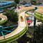 A person riding a yellow tube down a curving water slide at an outdoor water park.