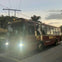 A maroon tour bus with "BIG BUS TOURS USA" and "BIGBUS.COM" branding parked on a street at dusk.