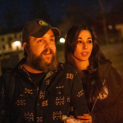 Couple staring into a lantern's glow as they listen to their tour guide